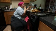 Brittani eating food in the kitchen.