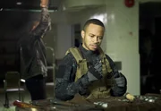 John Diggle (David Ramsey, l.) erhält eine Nachricht über den Aufenthaltsort seines verräterischen Bruders Andy (Eugene Byrd). Er verfolgt ihn in ein Lagerhaus - und tappt geradewegs in dessen Falle...