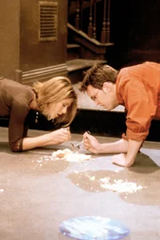 Friends "Das Leben ist süß". Im Bild: Rachel (Jennifer Aniston) und Chandler (Matthew Perry) sind so wild auf Käsekuchen, dass sie ihn auch vom Boden essen.