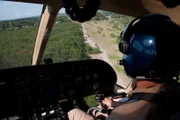 Laredo, TX: A Customs and Border Protection helicopter working with agents below on ATVs.