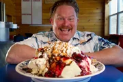 Host Casey Webb poses with Betty's Pies' Pigs Trough Challenge located in Two Harbors, Minnesota.