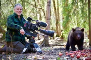 Gordon Buchanan and 6 month old Russian bear cub 'Pasha' the smallest and shyest member of the group. Location: Orphaned Bear Rescue Centre, Bubonitsy, Russia