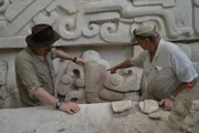 Josh Gates and Dr. Richard Hansen looking at large hieroglyphs at the Temple of the Jaguar Paw Ruins in El Mirador, Guatemala.