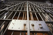 Looking up at prison bars, lock on cell door.