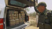 Brownsville, TX, USA: A U.S. Border Patrol agent looks at confiscated bundles filling up the back of his vehicle.