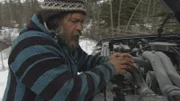 Closeup of Mark checking out his truck engine in the snow.