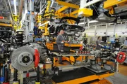 Factory workers prepare for the marriage of the Porsche body and engine.