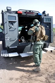 Nogales, Arizona, USA: A customs and border protection agent loads up his weapons and gear by an armored vehicle.

(Photo credit: © NGTV)