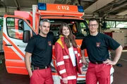 Reporterin Jana Heck mit den Rettungssanitätern Jerome (l) und Frank vom Rettungsdienst Duisburg.