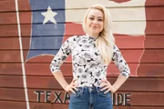 Portrait of Natalie Sideserf in front of a Texas flag mural at the Broken Spoke dancehall in Austin, Texas, as seen on Food Network's Texas Cake House.