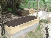 Ein wird ein Hochbeet im Garten gebaut.