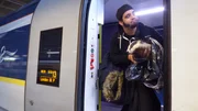 Episode Macabre. Jesse on the Eurostar with badger looking out door down platform.