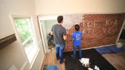 Ken Corsini (Left) and Anita Corsini white wash the brick wall to add character to their remodeled kitchen as seen on Flip or Flop Atlanta.