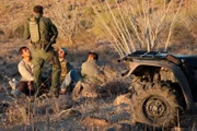 Nogales, AZ: An agent speaking with three apprehended men. With heightened security in populated cities, Border agents now arrest many illegal immigrants and smugglers in the desolate Organ Pipe Cactus National Monument.