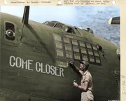 Crew chief of the Consolidated B-24 Liberator ?Come Closer? paints the 91st bomb on the nose of the plane to indicate the missions that the plane has flown. The three Japanese flags painted on the plane indicate that its crew shot down three Japanese Zeros. Saipan, Marianas Islands, 1944
