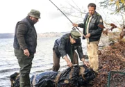 Hubert (Christian Tramitz, r.) und Staller (Helmfried von Lüttichau, M.) haben einen Schwarzfischer (Roberto Martinez, l.) gestellt. Am Haken hing statt eines kapitalen Hechts eine Leiche im Plastiksack.