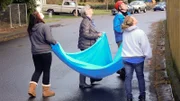 Kristyna Willers, Julie Bartlett, Carol Cuddy and Tom Otto hold a sheet open in case a cat falls in their direction.