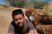 Jamie Crawford the presenter of 'In Too Deep' with a black breasted buzzard in Australia.