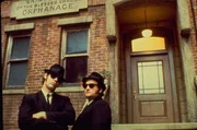 Schwarze Anzüge, schwarze Hüte, schwarze Sonnenbrillen und natürlich ein schwarzes Auto - so ziehen die Brüder Jake (John Belushi, r.) und Elwood Blues (Dan Aykroyd, l.) durch Detroit und hinterlassen eine Spur der Verwüstung hinter sich ...