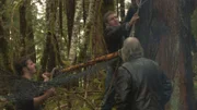 Matt, Gabe, and Billy raise a hammock at their campsite.