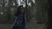 A woman fleeing coyotes in the woods.