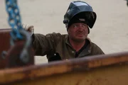 Freddy Dodge looking up wearing a welding helmet.