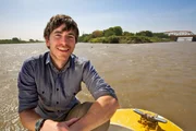 Episode 1 - The Nile
Simon Reeve on a boat at the confluence of the Nile, where the 'White' Nile and 'Blue' Nile meet in Khartoum