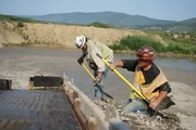 Freddy Dodge and Ben Hudak shovel dirt by Sluice Box.