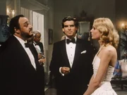 Quillan Gornt (l., John Rhys-Davis), Ian Dunross (M., Pierce Brosnan) und Casey Tcholok (Deborah Raffin), die VizeprSsidentin von Linc Bartletts Unternehmen, begegnen sich bei einer Party.