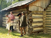 Ringmaster, King George, Bryan, and Clay perform a historical reenactment of a tax collector being punished at the hands of rebel farmers.