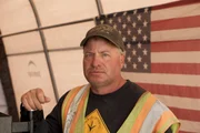 Freddy Dodge in front of American flag.