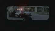 A police car through the woman's rear window.