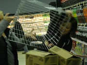 Aprille dumps groceries into her cart.