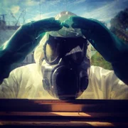 Man in hazmat suit looks through window.