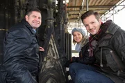 Die "Xenius"-Moderatoren Emilie und Adrian steigen mit Uwe Schäfer (li.), dem Hüttenmeister der Kölner Dombauhütte, auf das Gerüst am Kölner Dom.