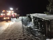 ORKANGER, NORWAY - Tow truck and team at work when a truck has flipped over on the side due to slippery conditions.