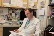 Dr. Holland reads in his office.