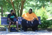 Drew talking to trainer on bench at the park.