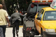 Ein Mann rennt seinem Taxi hinterher, dass gerade von Tremont Tow abgeschleppt wird.