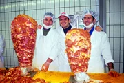 Dem "Dönerbau" auf heißer Spur! Kaya Yanar (M.) besucht eine Döner-Fabrik. Fleischspieße wohin das Auge reicht und Kaya Yanar mittendrin - hier zusammen mit zwei türkischen Arbeitern.