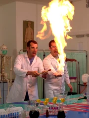 Dr. Chris (l., Chris van Tulleken) und Dr. Xand (r., Xand van Tulleken) zeigen die verschiedenen Energiemengen von Fürzen mithilfe der jeweiligen Stichflammengröüe.Â