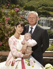 (5. Staffel) - Eigentlich hatte Doc Martin (Martin Clunes, r.) geplant, seine Karriere in London wiederaufzunehmen. Aber stattdessen hat er nach der Rückkehr von Louisa (Caroline Catz, l.) und der Geburt des gemeinsamen Babys mit seiner neuen Rolle als Partner und Vater zu kämpfen.