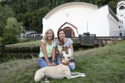 Moderatorin Simone Sombecki (r) und Inga Sprünken, Autorin, mit dem Whippet-Rüden Emile und Mischlingshündin Bijoux, vor dem Jugendstil-Kraftwerk Heimbach.