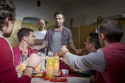 Victor Rodenko (Aleksandar Jovanovic, M.) gönnt sich vor den Mitinsassen (Kompasen) ein Glas von dem schwarzgebrannten Schnaps und kippt daraufhin um...