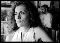 Artemis (Maria Tzivani) sitzt an der Strandbar am Tresen, während Nasos (Stavros Markalas) Getränke macht. Artemis (Maria Tzivani) sitzt an der Strandbar am Tresen, während Nasos (Stavros Markalas) Getränke macht.
