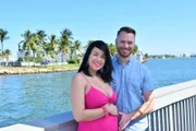 Russ and a pregnant Paola pose by the ocean for their hero shots.