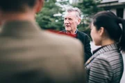 North Korea - Michael Palin and So Hyang talking to the military guards. (ITN Productions)