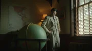 Trippe at globe hands on hips