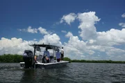 The crew travels on a boat in the Everglades.