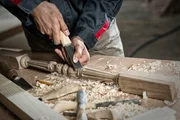 Close up carpenter's hands that work with cutter